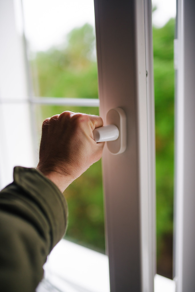 una mano apre una finestra che funziona dopo riparazione serramenti PVC